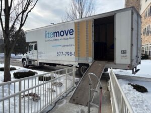 LiteMovers Truck with Hydraulic Ramp Extended for Loading | LiteMovers LiteMovers moving truck with rear door open and hydraulic lift ramp extended at residential building entrance during winter move